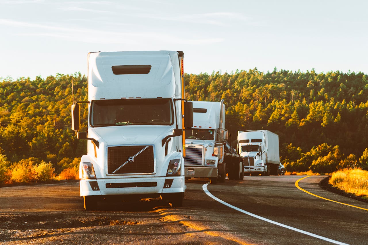 pexels photo 2199293 Three semi trucks driving on a highway